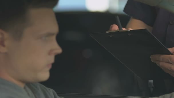 Policía escribiendo multa al hombre por licencia de conducir caducada, delito de tráfico — Vídeo de stock