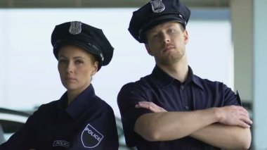 Ciddi görünümlü polis memurları şapkalı kamerada poz, ilçe güvenliği