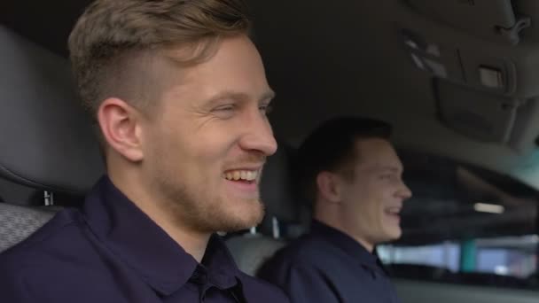 Vrolijke politieagenten lachen zitten in patrouille auto, vriendschap op het werk, Cops — Stockvideo