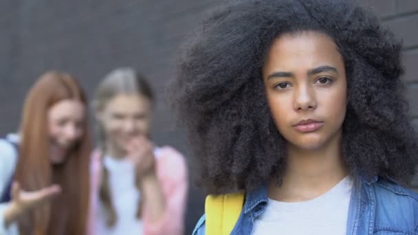 Porträt eines gemobbten birassischen Mädchens, Mitschüler, die sich hinterhermogeln, Rassismus-Bewusstsein — Stockvideo