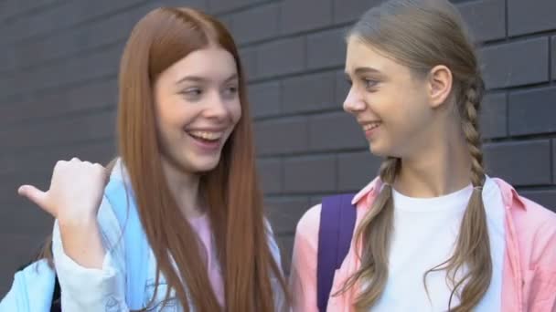 Tizenéves lányok pletykás az osztálytársa elhaladó, rossz pletykák, tiszteletet — Stock videók