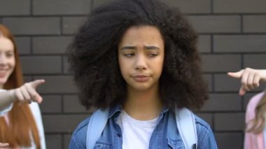Öğrenciler biracial kız, okulda ırkçılık, genç zulüm parmaklarını işaret