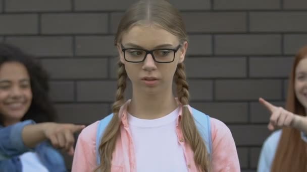 Adolescents moyens pointant du doigt la fille dans les lunettes, la cruauté et la haine des pairs — Video