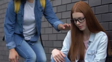 Kind kız dışlanmış kız öğrenciye dostluk sunuyor, zorbalık genç için yardım hattı