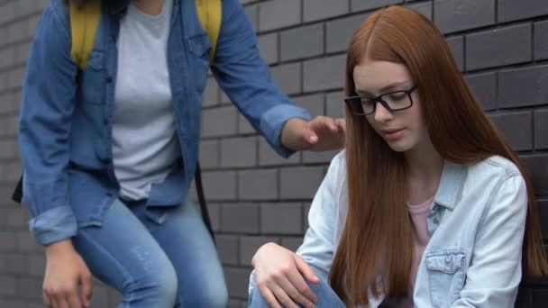 Chica amable ofrece amistad a una estudiante marginada, línea de ayuda para adolescentes acosados — Vídeo de stock