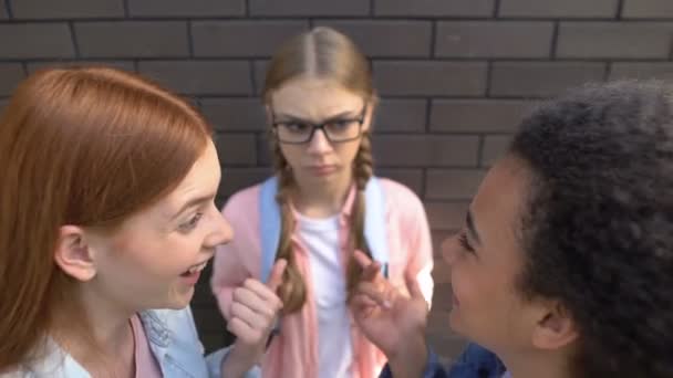 Одноклассники смеются над красивой девушкой в очках, злонамеренно дразнят, запугивают — стоковое видео