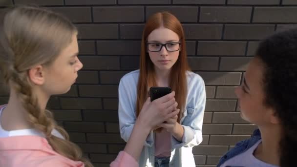 Bully adolescentes tomando el teléfono de su compañero de clase, burlándose de la cuenta de redes sociales — Vídeo de stock