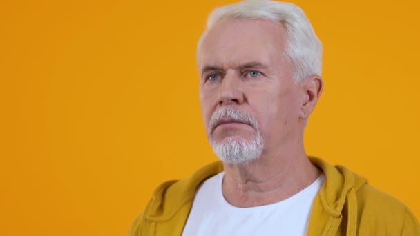 Verärgerter älterer Mann auf orangefarbenem Hintergrund, Fehler Enttäuschung, Versagensreaktion — Stockvideo
