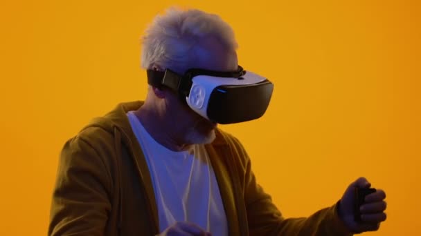 Hombre anciano con auriculares de realidad virtual, juego de ciberespacio, dispositivo de entretenimiento — Vídeos de Stock