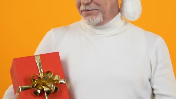 Uomo maturo che punta alla scatola regalo rossa, celebrazione di Natale, sorpresa delle vacanze — Video Stock