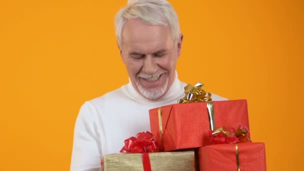 Glad senior mâle tenant des boîtes cadeaux dans les mains, préparation des vacances, surprise — Video