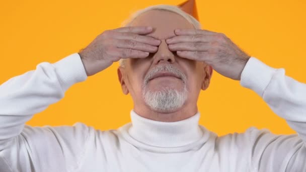 Reifer Mann mit Partyhut, entblößende Augen, Blick auf Überraschung, Urlaubsgruß — Stockvideo