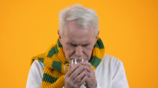 Hombre viejo que bebe la medicación caliente líquido que sufre la gripe, síntomas reducen, resfriado — Vídeo de stock
