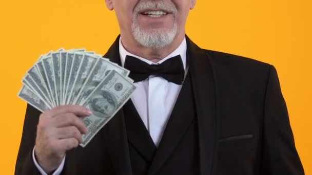 Cheerful gentleman pointing at dollars in hand, salary payment, easy credit — Stock Video