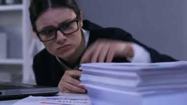 Motivasyonsuz stresli ofis çalışanı kağıtlar üzerinden bakarak, iş aşırı yakın çekim