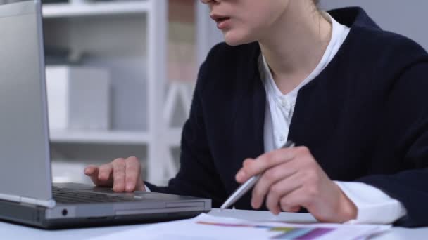 Žena porovnávající finanční grafy na papírech a laptopu, příprava zprávy — Stock video