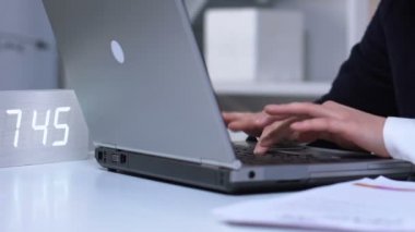 İşi bitiren ve dizüstü bilgisayarı kapatan kişi, saat üzerinde ek çalışma saatleri