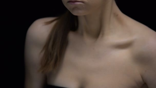 Глубоко плачущая голая девушка отворачивается от камеры, слово уродливое на плече, унижение — стоковое видео