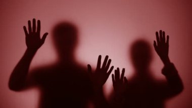 İnsanların siluetleri camda kayar, savaştan ölür, kırmızı ışık yanıp sönme