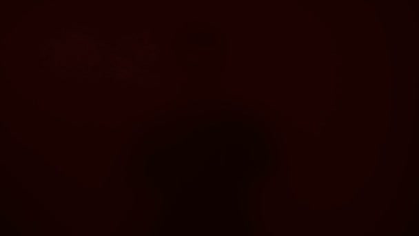 Ανδρική σιλουέτα κοιτάζοντας μέσα από γυάλινο τοίχο, κόκκινα φώτα που αναβοσβήνουν στο παρασκήνιο — Αρχείο Βίντεο