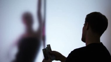 Striptiz dans gösterisi izlerken para tutan adam, ıslık çalmak, kadın elbiselerini çıkarıyor
