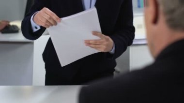 Genç kadın mali yönetmen, ofiste kadın asistan raporu gösteren