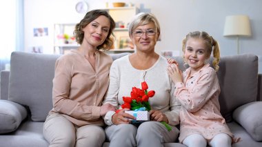 Anne ve kızı lale ile Büyükanne sarılmak ve el mevcut, tatil