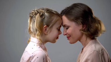 Sevimli kız ve anne dokunmadan foreheads, kadın dostluk, aile desteği