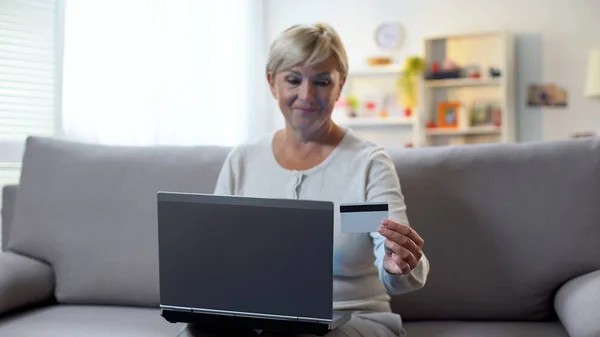 Ältere Blonde Frau Eingabe Von Kreditkartennummer Auf Laptop Sitzend Sofa — Stockfoto