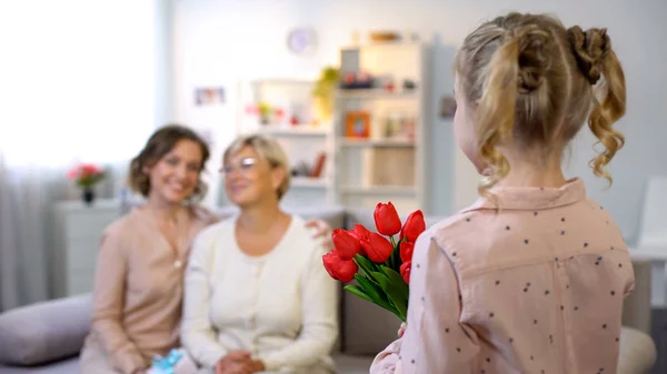Зріла Мати Дочка Дивляться Маленьку Дівчинку Даруючи Тюльпани Приємні Моменти — стокове фото