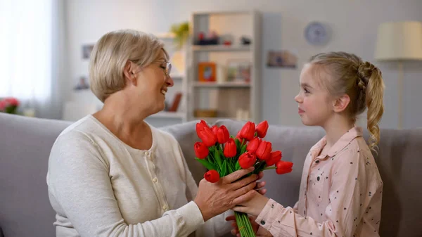 Красивая Девушка Дарит Красные Тюльпаны Бабушке Семейная Любовь Празднование Дня — стоковое фото