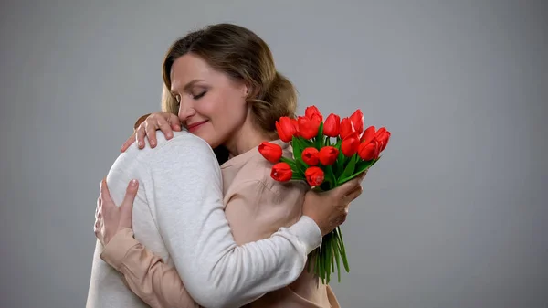 Donne Che Abbracciano Madre Adulta Che Tiene Bouquet Tulipani Festa — Foto Stock