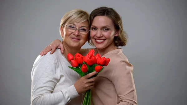 Весела Мати Дочка Посміхаються Дивляться Камеру Тримаючи Тюльпани — стокове фото