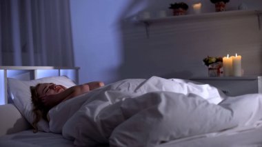 Şizofreni hastası, kafasında sesler duyan, yatakta yatan akıl hastası kadın