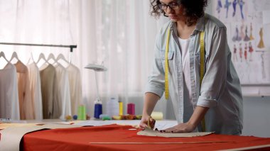 Kumaştan konsantre terzi kesme iş parçası, atölye üzerinde çalışan kadın