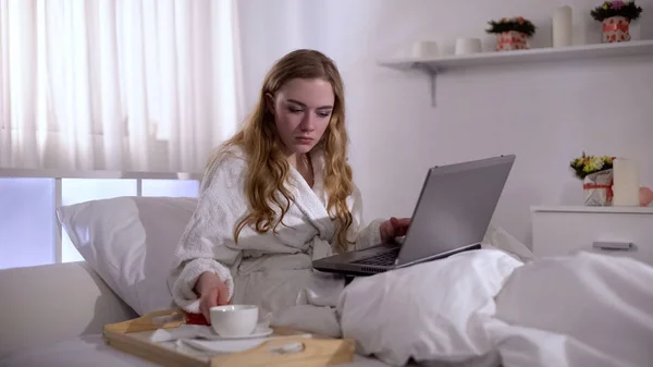 Κορίτσι Ρόμπα Κούπα Καφέ Στο Κρεβάτι Δουλεύοντας Για Laptop Ανεξάρτητη — Φωτογραφία Αρχείου