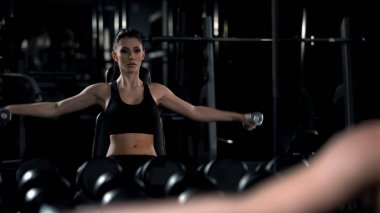 Güzel bayan ofis çalışmasından sonra spor salonunda sert egzersiz yapıyor, ayna yansıması