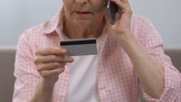 Tarjeta de crédito femenina de edad avanzada y línea directa bancaria de llamada, consultoría financiera — Vídeos de Stock
