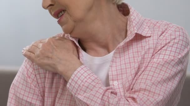 Пожилая женщина массирует больное плечо, страдает от болезней суставов, здоровья — стоковое видео