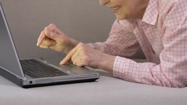 Счастливая пожилая женщина, сидящая на ноутбуке, обсуждает в соцсетях технологии — стоковое видео
