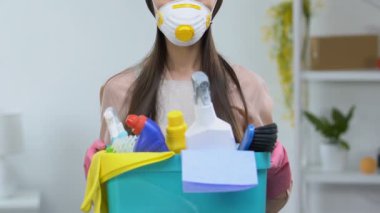 Deterjanlar, tehlikeli kimyasallar ile respiratör tutan sepet ev hanımı