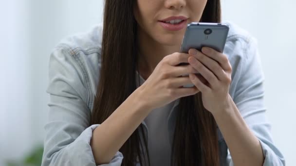 Joven mujer sonriente mensaje de texto en el teléfono inteligente a la amada, nuevas relaciones — Vídeos de Stock