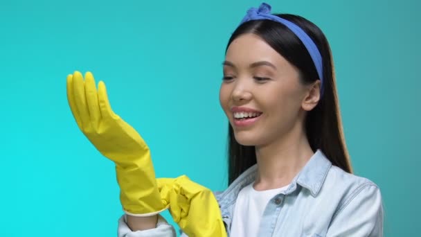 Femme au foyer souriante dans des gants montrant un geste correct et clignant des yeux à la caméra, corvées — Video