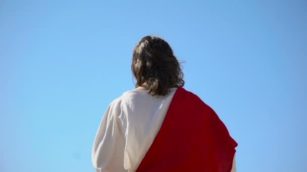 Saint prophet holding cross, praying to God, preaching Christianity back view — Stock Video