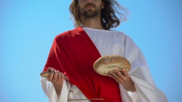 El hombre con la túnica sosteniendo el pescado y el pan, concepto de caridad para alimentar hambriento, generosidad — Vídeo de stock