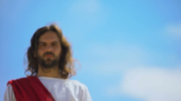 Gesù si avvicina alla macchina fotografica, guardando con misericordia, perdonando i peccati, vista dal basso — Video Stock