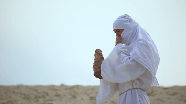 사막에서 병에서 물을 마시는 목마른 아랍 순례자, 가뭄 문제 — 비디오