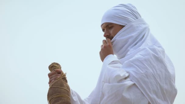 Árabe codiciosamente bebiendo de la botella, manteniendo el equilibrio de agua, sed en el desierto — Vídeo de stock