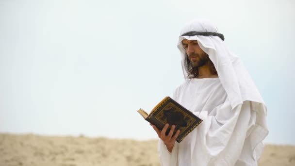 Lectura árabe del Corán en el desierto, meditando y reflexionando sobre las enseñanzas de Muhammad — Vídeos de Stock