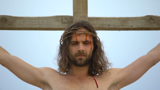 İsa gökyüzüne bakarak çapraz çivilenmiş, kan damlası yüz aşağı akan, çarmıha germe — Stok video